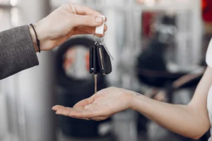 Pengemudi memegang setir mobil rental, menggambarkan pilihan lepas kunci atau dengan driver